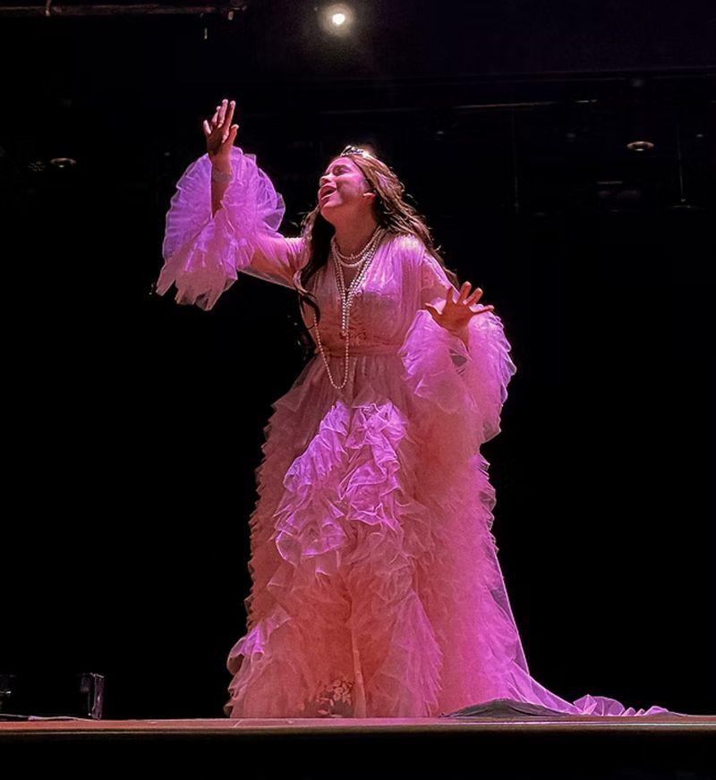Frankie as Cunegonde in a pink feathered gown, from Candide