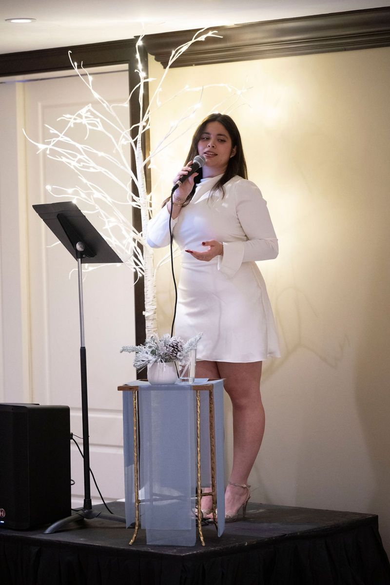 Frankie singing in a white dress at the House of Hope Benefit Dinner